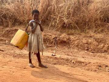 Kind beim Wasser holen